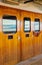 Cruise ship heavy varnished wood exterior doors with windows reflecting the sea.