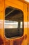 Cruise ship heavy wooden varnished exterior door with window reflecting the sea.