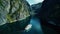 Cruise ship navigating through a narrow Norwegian fjord, towering rock walls.