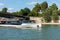 Cruise ship passing through the iron bridge acrossing the Seine river on a sunny day in Paris, France