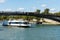 Cruise ship passing through the iron bridge acrossing the Seine river on a sunny day in Paris, France