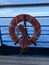 A cruise ship sign life ring hanging on the railing to be used in case of emergency