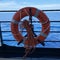 A cruise ship sign life ring hanging on the railing to be used in case of emergency