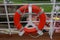 A cruise ship sign life ring hanging on the railing to be used in case of emergency with the sea in the background