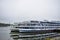 Cruise ships at the river pier, the water surface reflects the retro tourist transport, fog and clouds