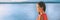 Cruise travel Asian woman banner on ocean or lake panorama view with copy space on water. Elegant Chinese lady enjoying sunset