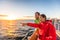 Cruise travel tourists couple pointing at sea view from ferry tour. Asian woman multiracial people traveling together at sunset