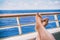 Cruise vacation travel woman relaxing with feet on balcony ship deck at view of ocean on honeymoon boat voyage destination.