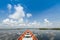 Cruising wooden boat in the lake with cloudy blue sky background