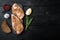 Crumbed uncooked chicken breast ingredient, on black wooden background, top view with space for text