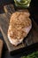 Crumbed uncooked chicken breast ingredient on wooden table