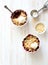 Crumble with berries, apples, ball of ice cream and almond in white bowls close up