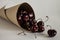 Crumbled berries of ripe cherries in a paper rolled bag close-up