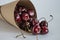 Crumbled berries of ripe cherries in a paper rolled bag close-up