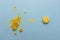 Crumbled yellow macaroon cookie arrow points to unbroken macaroon on blue flat background