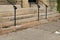 Crumbling limestone exterior steps of a church, black metal handrails, weathered and worn