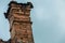 Crumbling old brick chimney on abandoned house