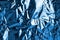 Crumpled dark blue foil shining texture background, bright shiny cold icy design, metallic glitter surface