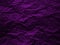 Crumpled dark violet paper texture background