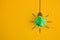 Crumpled green paper light bulb on yellow background