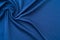 Crumpled knitted dark blue fabric. Abstract wrinkled cloth background