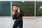 Crumpled paper balls flying at frightened male teacher in classroom with chalkboard