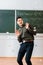 Crumpled paper balls flying at frightened male teacher in classroom with chalkboard