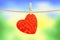 Crumpled paper heart hanging on rope over nature background