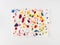 Crumpled paper splattered with vibrant multicolor paint on white background. Minimal composition. Flat lay