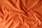 Crumpled reddish orange artificial suede fabric