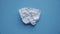 Crumpled square white checkered paper sheet gradually leveled on blue background top view, Full HD format. Stop motion animation