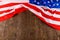 crumpled usa flag on flat textured wooden surface background