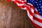 crumpled usa flag on flat textured wooden surface background