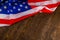 crumpled usa flag on flat textured wooden surface background