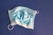 Crumpled used medical protective mask on a blue background