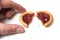 crunched mini tartlets with strawberry jam in hand on white background