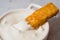 Crunchy breaded fish stick made from wild caught Alaskan Pollock dipped in greek yogurt garlic dipping sauce close-up