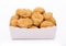 Crunchy chicken popcorn bites in kids paper square cup for fast food meals on white background