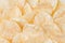 Crunchy golden potato chips pattern, top view, background.