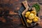 Crushed, Broken potatoes baked in oil with herbs. Wooden background. Top view. Copy space