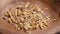 Crushed dried licorice root falling into a wooden dish in slow motion. Herbal detox ingredient.