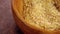 Crushed flax seeds in rustic wooden bowl. Macro. Rotation.