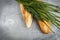 Crusty fresh seasoned baguette with sesame with fresh herbs on rustic wooden background