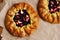 Crusty galette or open pies with fruits and berries