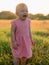 Crying baby in pink dress. Child girl in outdoor with sunset tones