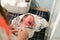 Crying baby when swaddling. A newborn 1 week old baby being examined by a pediatrician