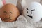 Crying brown egg next to angry white egg