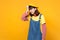 Crying displeased girl teenager in french beret, denim sundress keeping eyes closed, putting hand to head isolated on