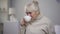 Crying elderly woman drinking tea at nursing house, loneliness in old age