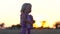 Crying little girl alone in the meadow. Child at sunset in the meadow.